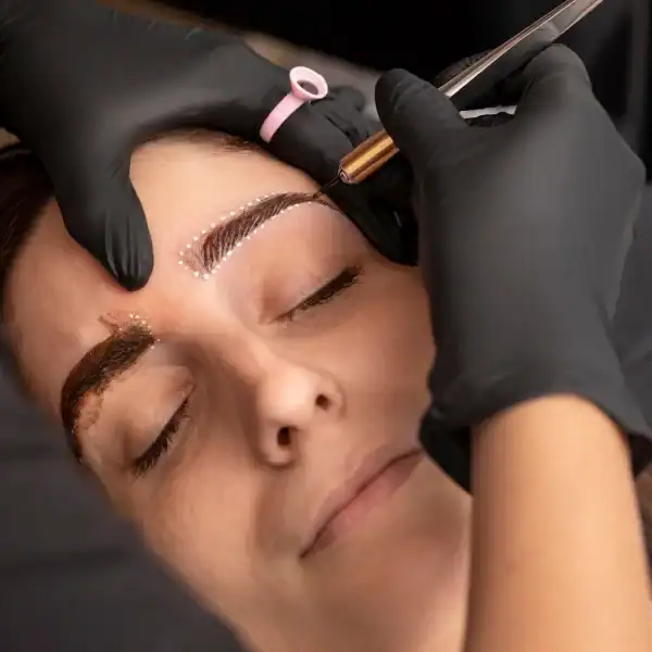 Une femme se fait épiler les sourcils par une professionnelle dans un salon de beauté.