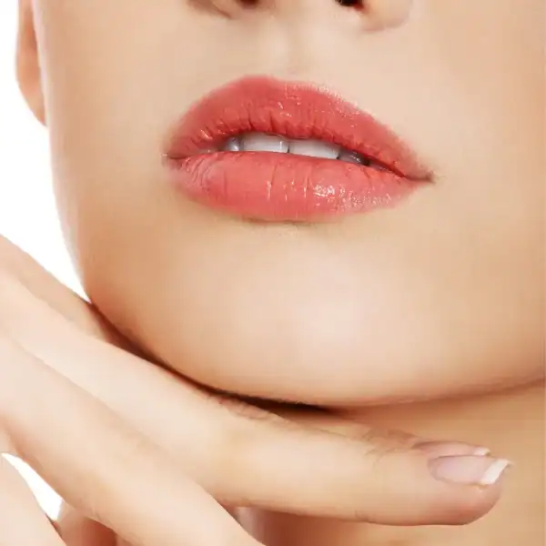 Femme avec des lèvres rouges et une manucure blanche.